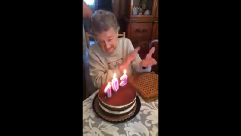 Бабушка задувает праздничный торт