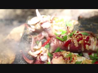 Primitive technology cooking squid on a steel for lunch in the woods wilder