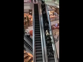 Police pushing and beating citizen with batons during their rush down the escalator
