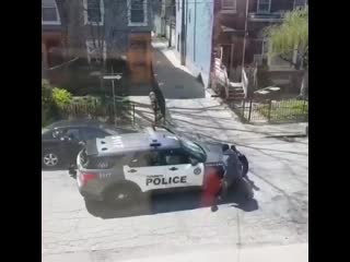 Die afrikanerin in toronto, kanada, jagt eine polizistin mit einem ziegelstein um ihr fahrzeug