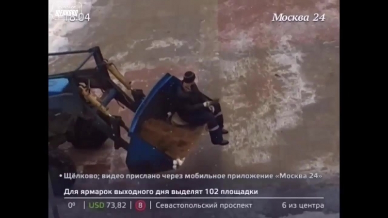 В щелкове рабочий разбросал песок, сидя в тракторном ковше