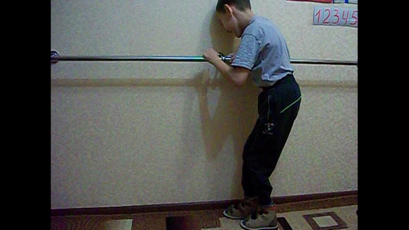 Наиль учится шагать возле поручня
