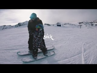 Four year old snowboarder rides with his dad