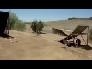 Freestyle motocross, guy hitting 50 foot kickers with dog on dirtbike