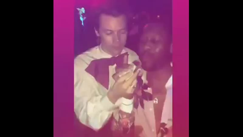 Harry feeding a grilled cheese sandwich to a guy at the gucci vs guccy metgala after party may