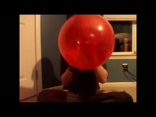 Cute redhead blows up a red balloon and sits on it but it deflates