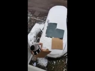 Lad covers his windscreen with cardboard box to avoid getting it snowed on