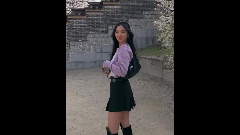 Худая азиатка в юбке позирует и смеётся