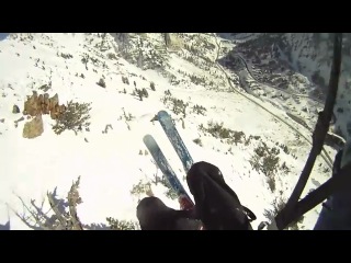 Горнолыжник спускается с большого склона с парашютом