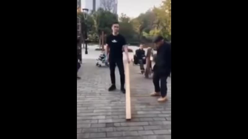 Дедушка показывает молодому парню как поднять доску одной рукой