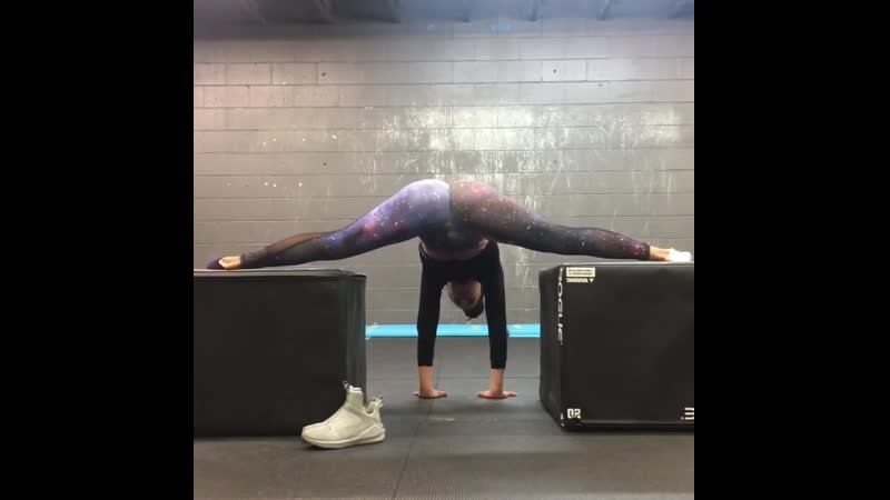 Девушка в космических легинцах делает шпагат и тренирои на попу