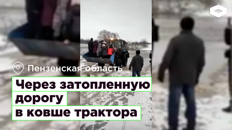 Через затопленную дорогу в ковше трактора