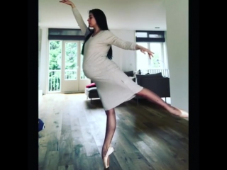 Pregnant ballerina balancing en pointe