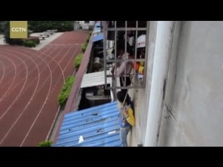 12 year old boy climbed up a roof to hold up a 7 year old girl on his shoulders, to ease her pain