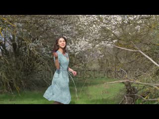 Stock footage beautiful young brunette caucasian girl walking in spring garden in bloom seasonal romantic scene webm