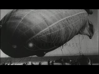 Gunner in military biplane shoots down a large blimp in the air over chicago stock footage