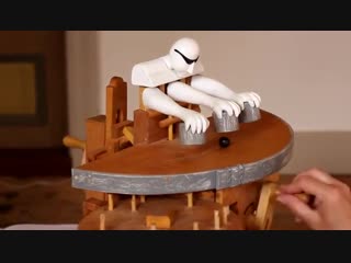 Manually cranked wood toy performs sleight of hand magic