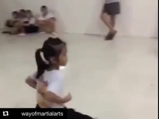 Маленькая девочка отрабатывает удары в низкой стойке