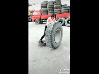 Хрупкая девушка лоо обращается с огромным колесом