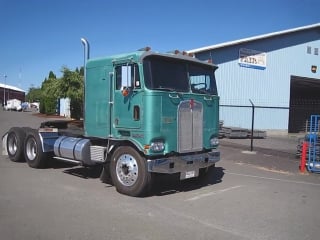 Kenworth k100 is leaving a truckstop