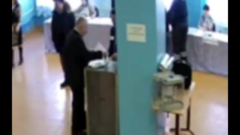 Член комиссии вместе с охранником вбрасывают огромное количество бюллетеней