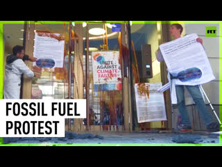 Protesters spray oil & throw coal at company investing in fossil fuels