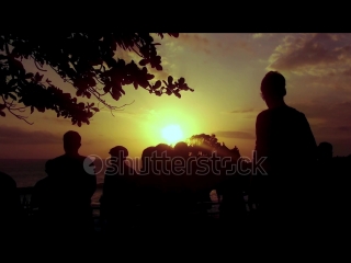 Silhouette of walking people on sunset beach view batu bolong at tanah lot, tabanan, bali, indonesia