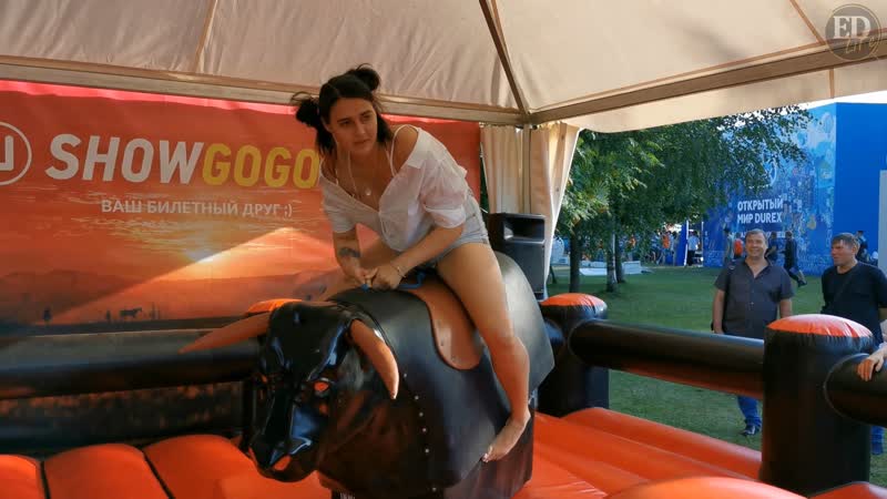 Попытка оседлать быка – девушка на аттракционе «родео»