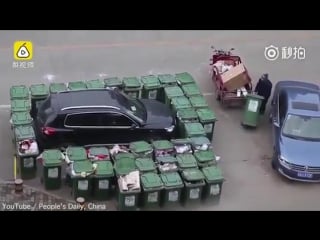 Raging street sweeper blocks badly parked car with trash cans