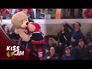 Mascot giving big teddy bear to girl in front of everybody at the game