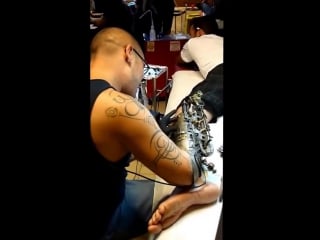The tattoo artist jc lyons sheitan tenet makes a tattoo with a biomechanical arm
