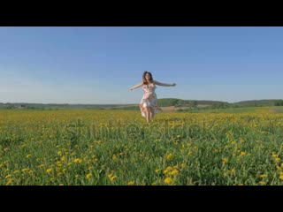 Stock footage beauty young happy free caucasian woman in a dress runs to a towards to camera through a blooming mp4