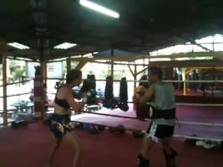 Angela from toronto smashing kru dohs pads at santai muay thai, chiang mai