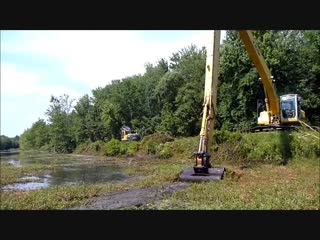 Long reach excavator dredging canal