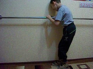 Наиль учится шагать возле поручня