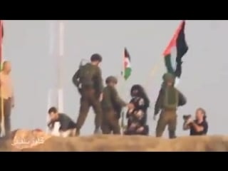 #solidarity activists raise the flags of #palestine behind the site of an israeli sniper on the #gaza border