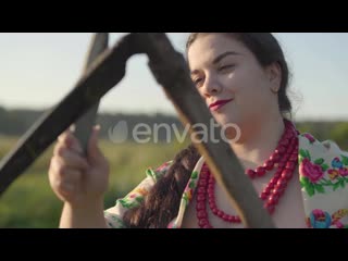 24191836 overweight woman sharpening scythe preparing to start mow on the green summer field by photo oles preview