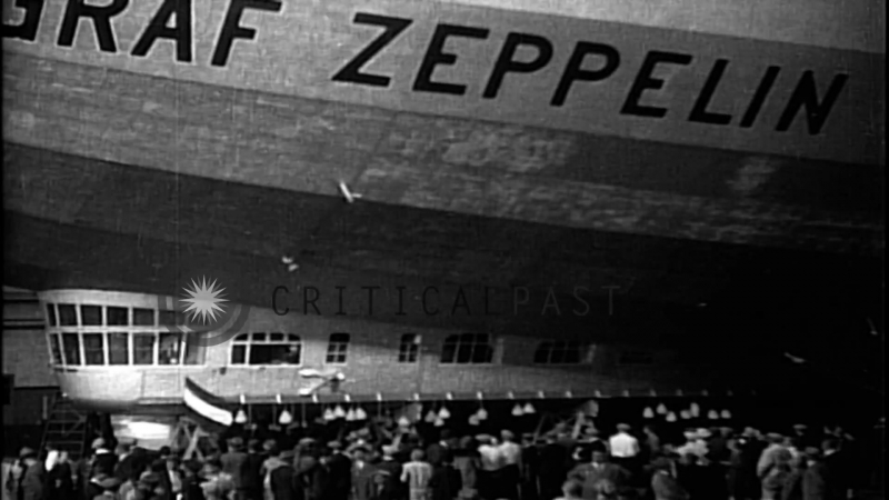 Men repair damaged fin of lz 127 graf zeppelin airship in hangar after arriving stock footage