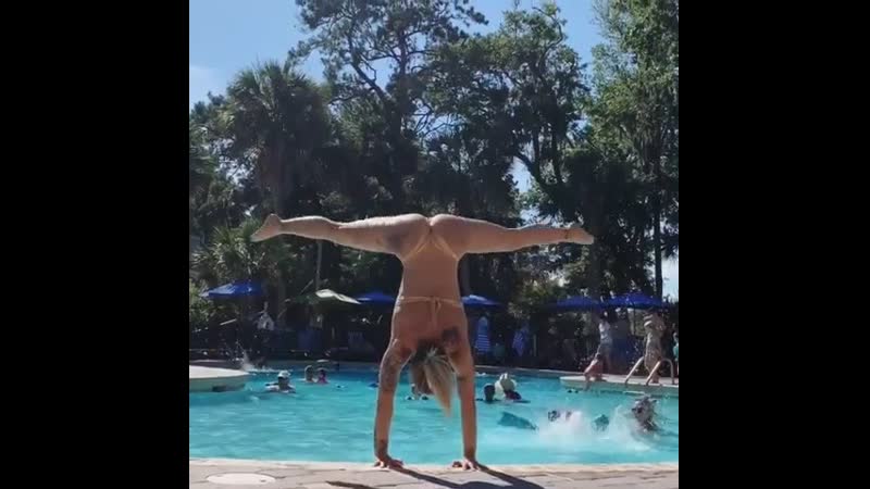 Девушка в бассейне делает силовые выходы в стойку