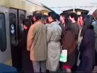 'pushers' pushing people on a crowded japanese train