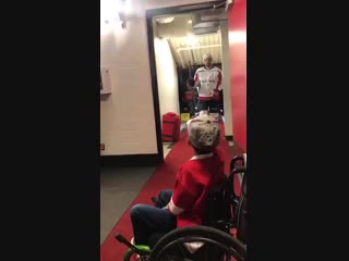 Capitals fist bumping a young fan in a wheelchair waiting in their saddledome dressing room