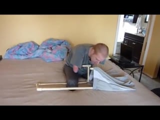 Quad amputee uses dressing assistance device (dad) to put his pants on