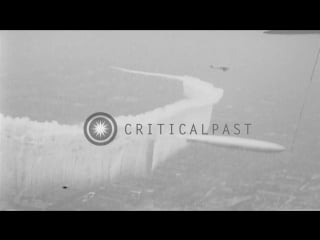 Skywriting airplane welcomes graf zeppelin by encircling it with heavy vapor stock footage