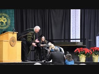 Good boy receiving an honorary diploma when his handler graduates from college