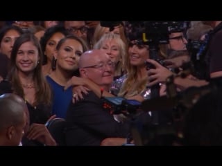 Heidi klum sits on the lap of james cordens dad audience cam 59th grammys