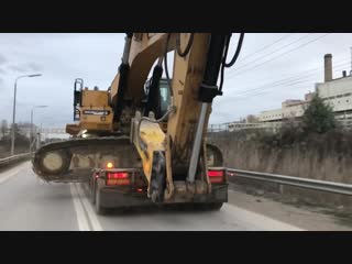 Transporting the cat 385c by side heavy transports