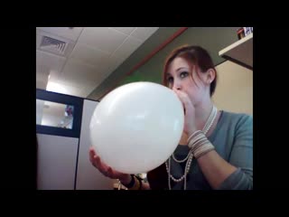 Cute redhead threatens to pinpop balloon she blew up in her office cubicle