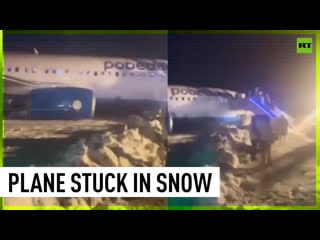 Airplane skids off runway, gets stuck in snow
