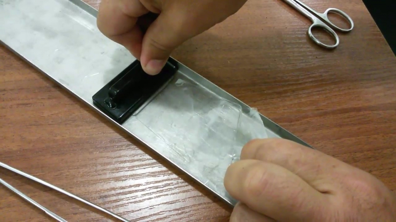 Криминалисты снимают отпечатки пальцев со смятого скотча