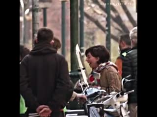 Lady gaga and adam driver laughing on the set of house of gucci as adam’s vespa starts to